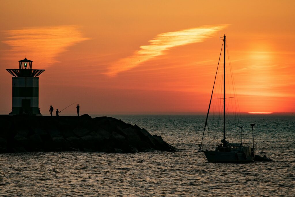 silhouette of boat on sea during sunset