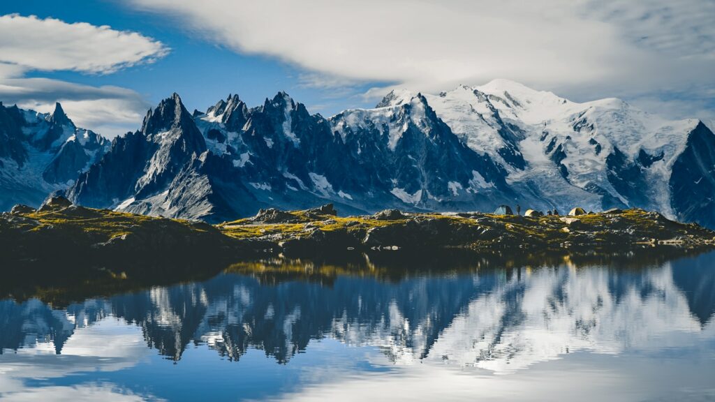 snow covered mountain near lake during daytime