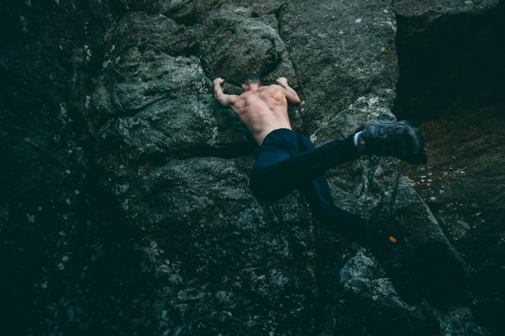 man rock climbing on gray rock