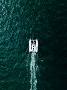 people riding on pontoon boat on body of water during daytime